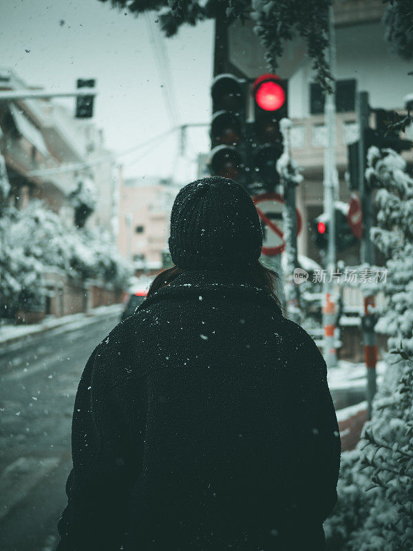 在一个寒冷的冬天，一个女人在街上的背影