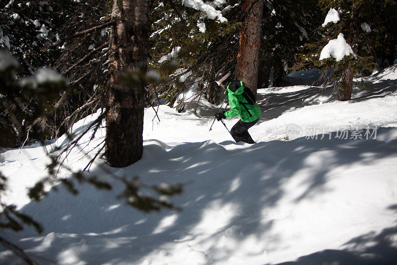专业成熟的女子滑雪者在树木和雪峰之间。科罗拉多州的汽船滑雪胜地。