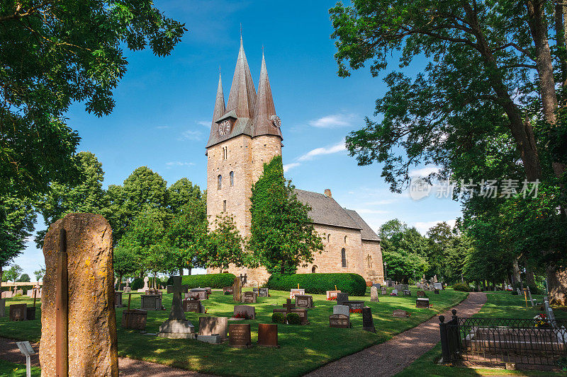 瑞典南部的中世纪Husaby教堂。前景是墓碑