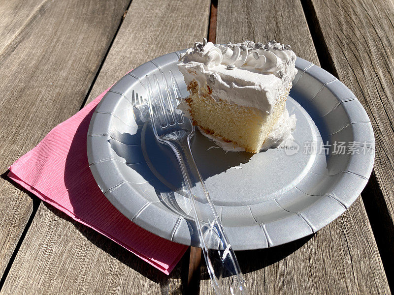 野餐桌上的香草糖霜白色蛋糕切片