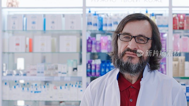 肖像照片的药剂师拿着一个瓶子在药房