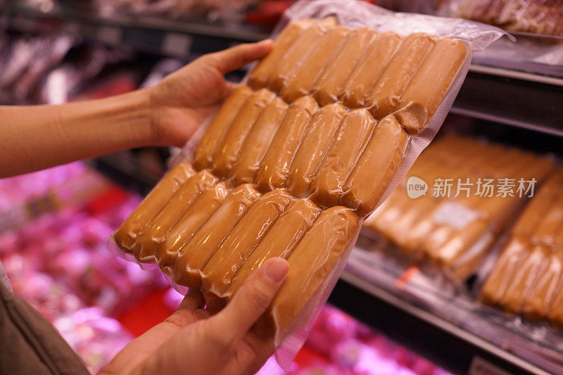一名女子在超市加工肉制品区挑选香肠的短镜头