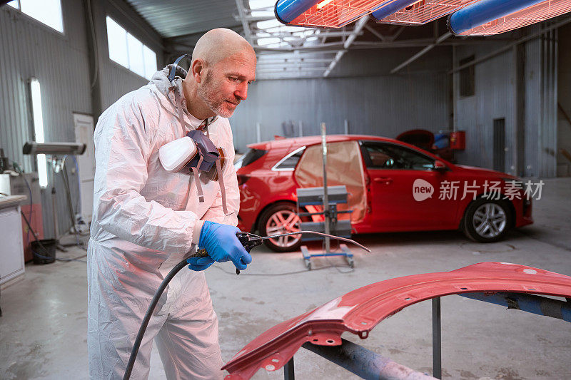 乐观的男性在工作工作服拿起油漆的汽车