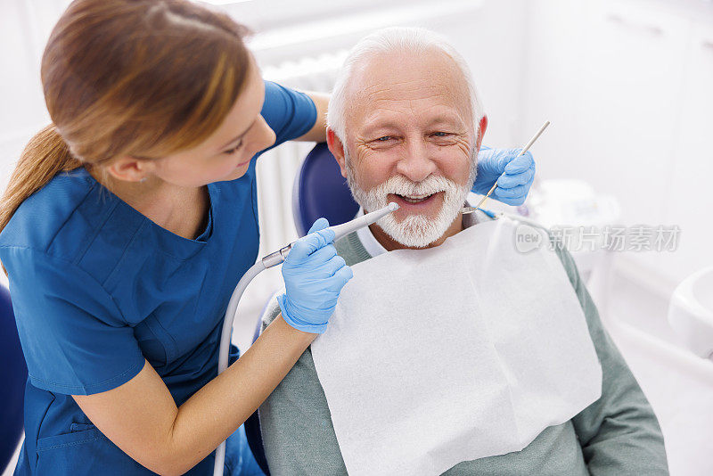 女牙医用牙钻给病人矫正牙齿
