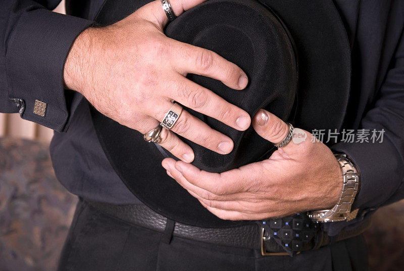牛仔和手戴戒指珠宝和葬礼上的黑帽子