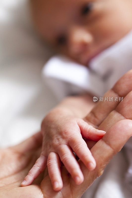 新生儿握着母亲的手