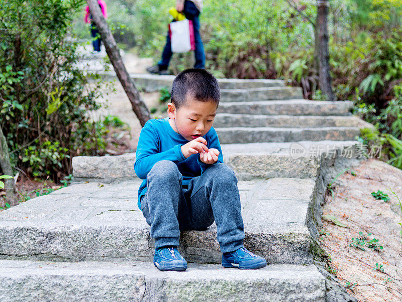 小男孩坐在楼梯上