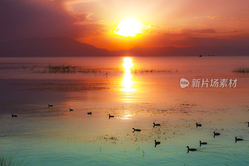 红黄相间的夕阳映在水面上