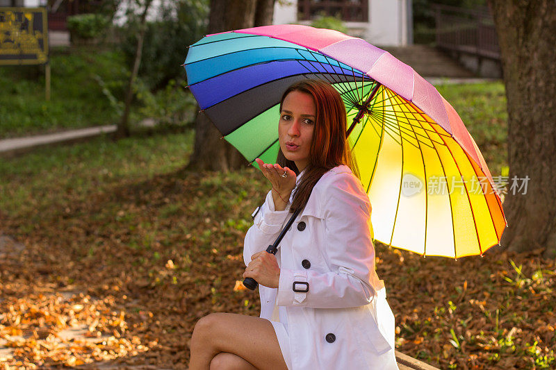 黑发女孩在森林里拿着五颜六色的雨伞