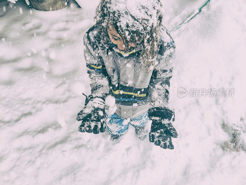 女孩试图在暴风雪中赶上雪