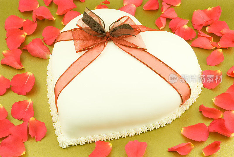 心形蛋糕，红丝带和玫瑰花瓣