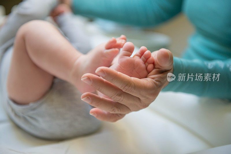 婴儿的脚在妈妈的手中关闭