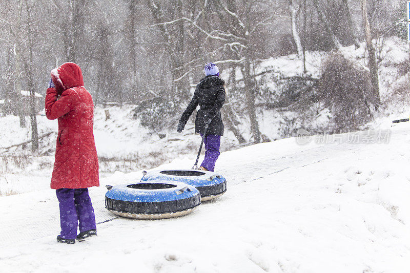 Snowtubing。两个女孩要去山顶