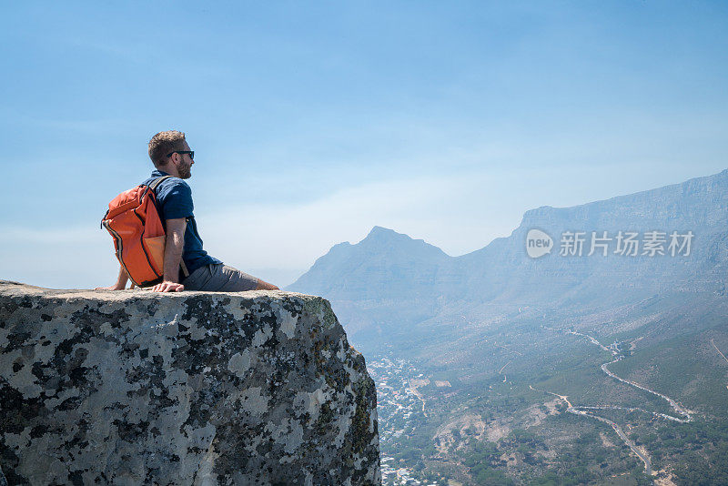 一个年轻人在开普敦山顶上看风景