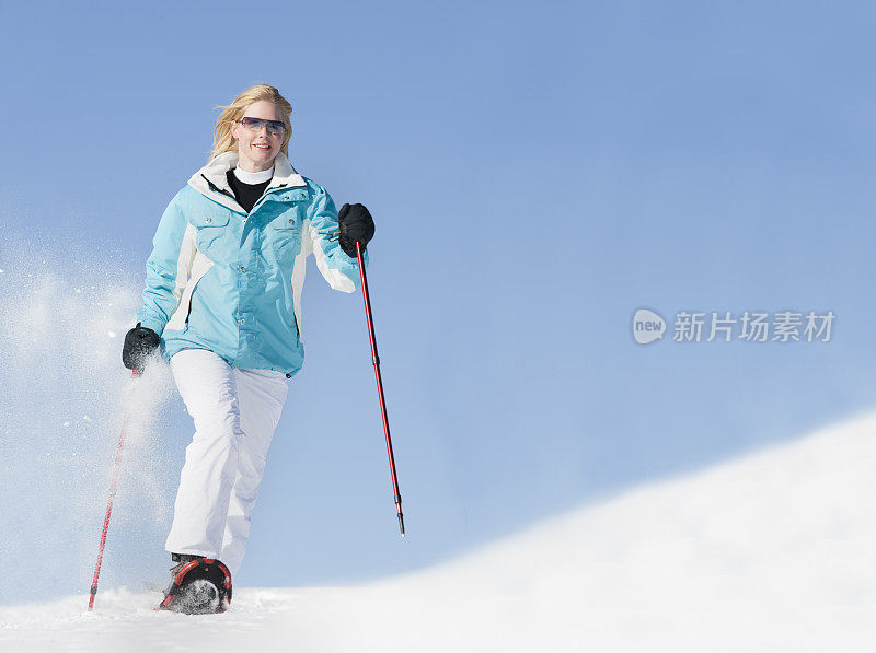 在粉雪中穿雪鞋的女人