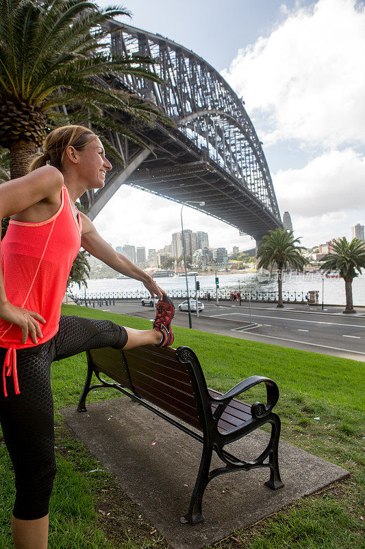 年轻女子在悉尼海港大桥边伸展身体