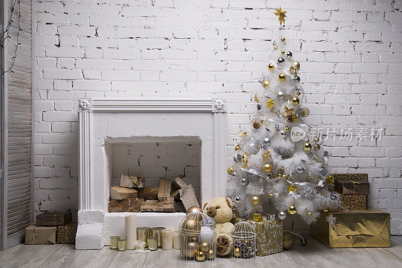 白色圣诞树上有金色和银色的球，礼盒