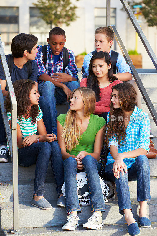 一群形形色色的青少年坐在台阶上聊天
