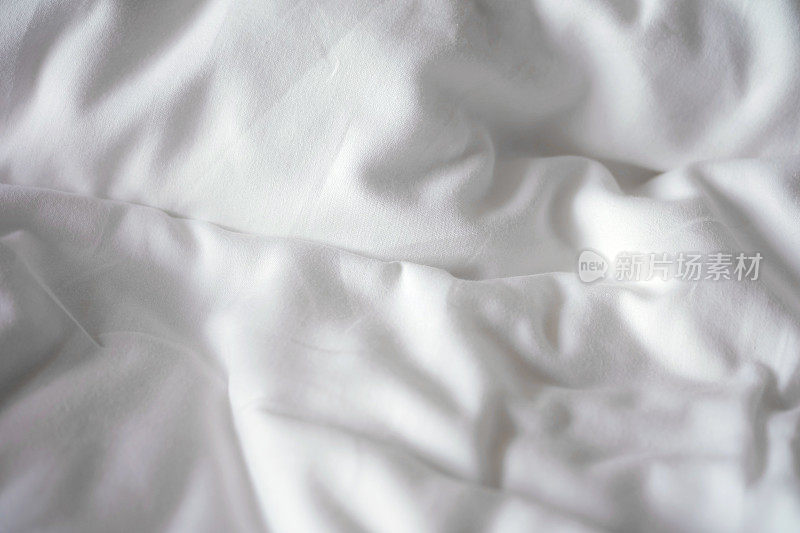 床单柔软白色褶皱纹理背景。