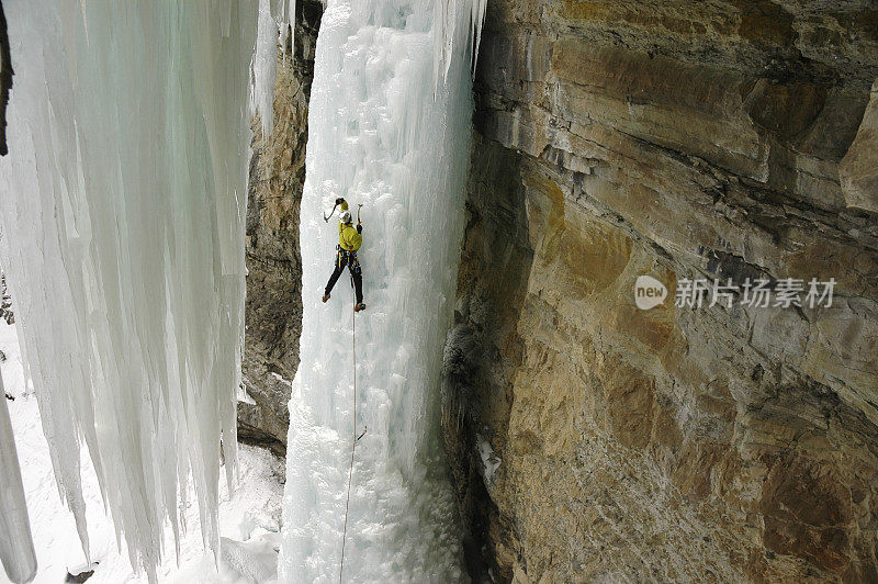 冰攀登者在陡峭的冰冻瀑布上的极端冒险家