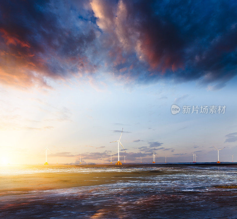 日落时的风力涡轮机和电力塔