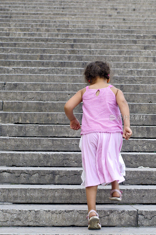 小女孩(5-6)在户外垂直爬楼梯