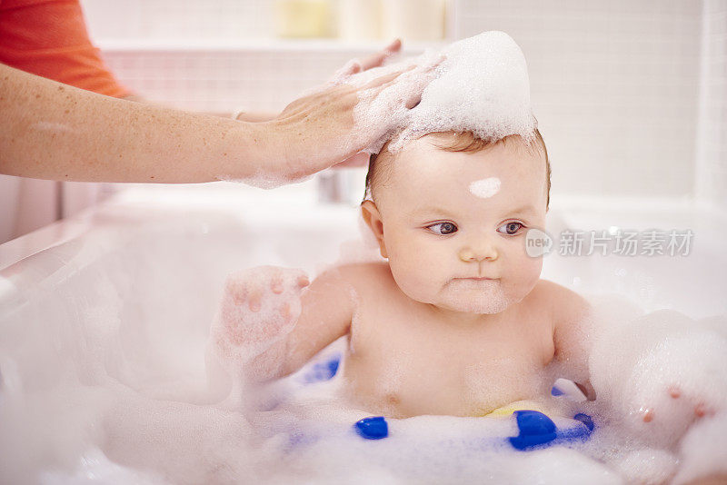 小男孩坐在浴缸里洗头