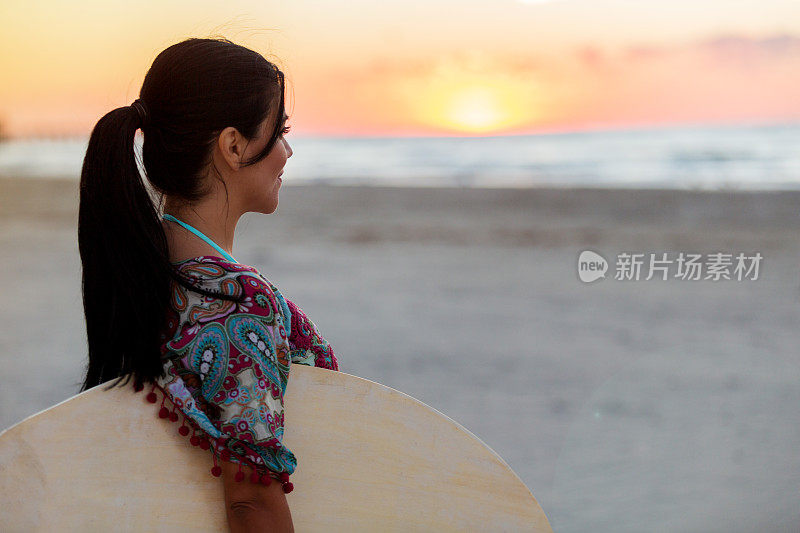 一个女人在日落时眺望大海