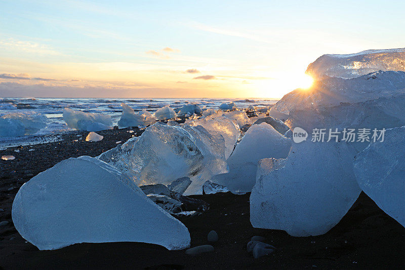 冰岛Jokulsarlon冰川泻湖海滩，日落时的冰冻冰创作