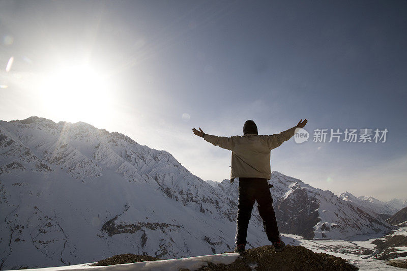 在白雪覆盖的喜马拉雅山上，一个张开双臂的男人