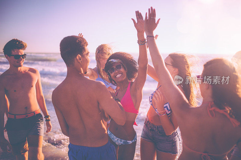 一群混合种族的朋友在海滩上玩得很开心