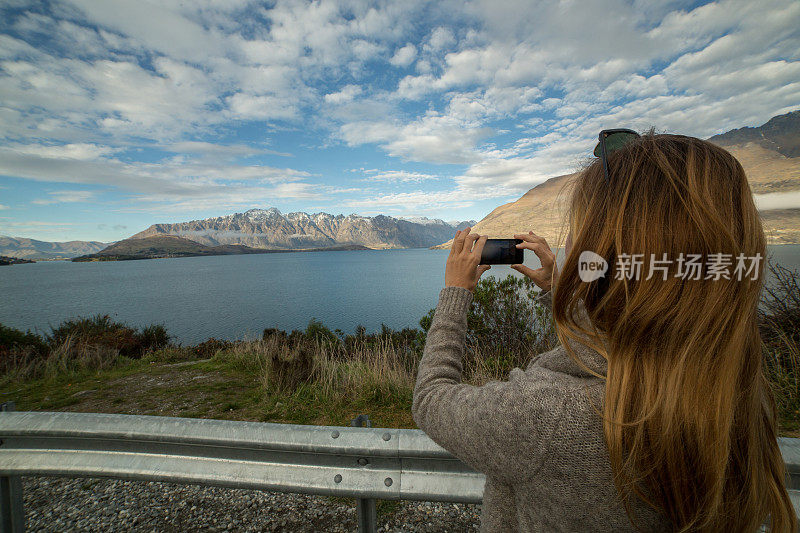 女人从lookout用智能手机拍摄风景