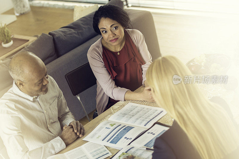 一对西班牙夫妇在和一位女性保险代理人聊天