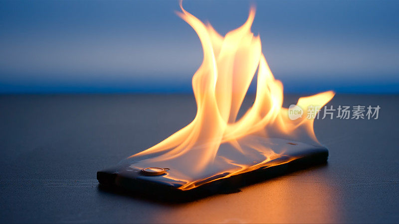晚上，智能手机躺在桌子上燃烧着