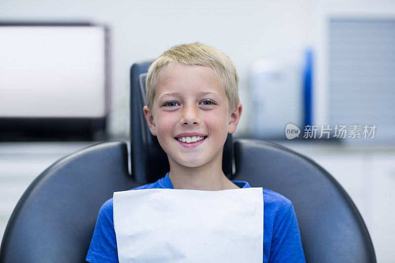 微笑的年轻病人坐在牙医的椅子上