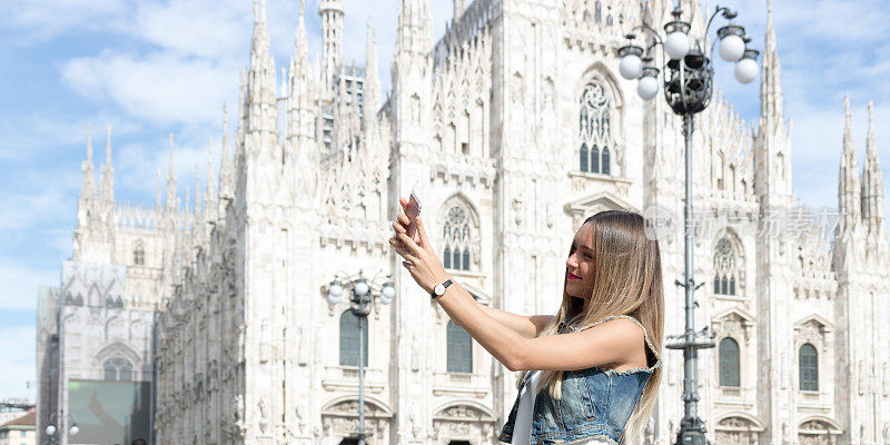 在意大利米兰，年轻漂亮的游客用她的手机自拍