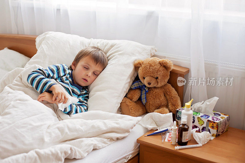 生病的小男孩发烧躺在床上休息