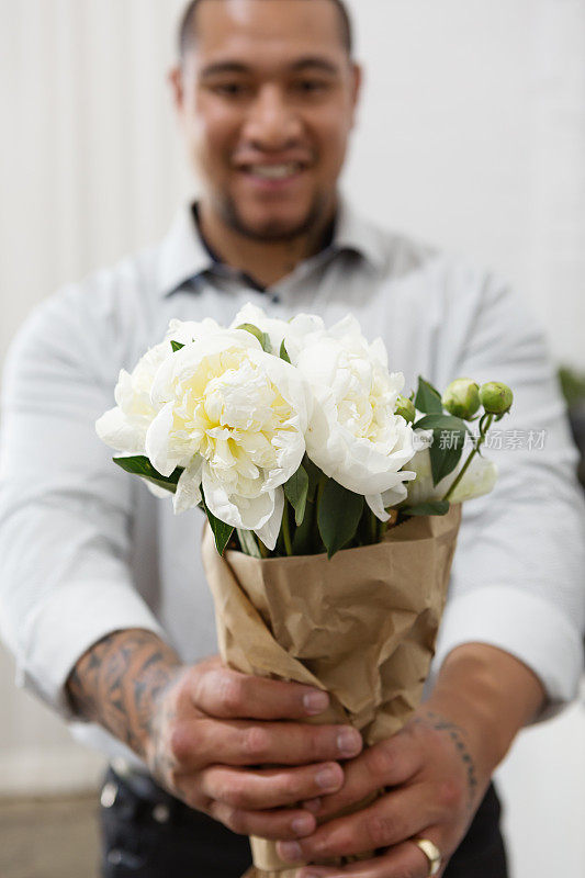 丈夫向镜头献上一束美丽的白花