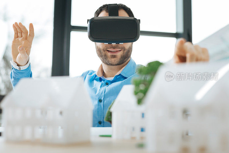 兴高采烈的人戴着VR头盔看房子模型