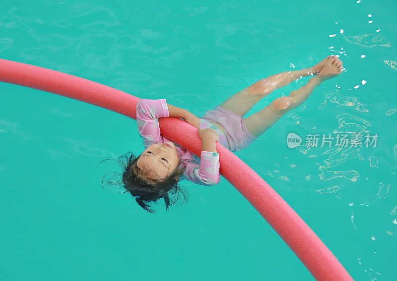 小女孩在游泳池训练。