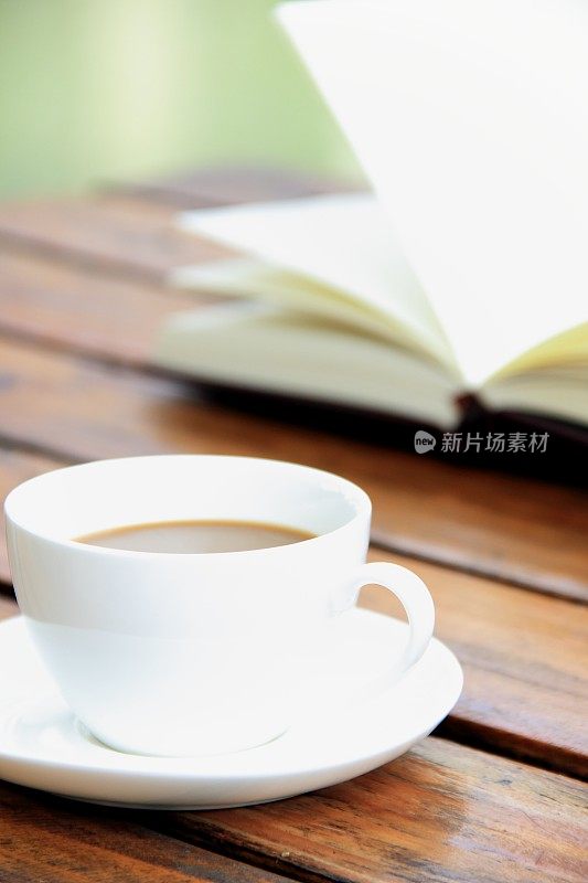 书和咖啡杯放在户外的桌子上