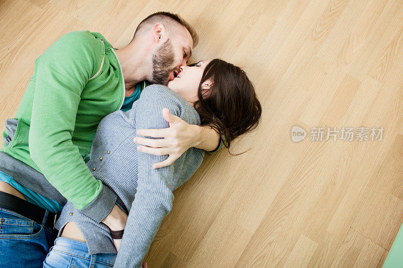 一对夫妇躺在厨房的地板上拥抱着