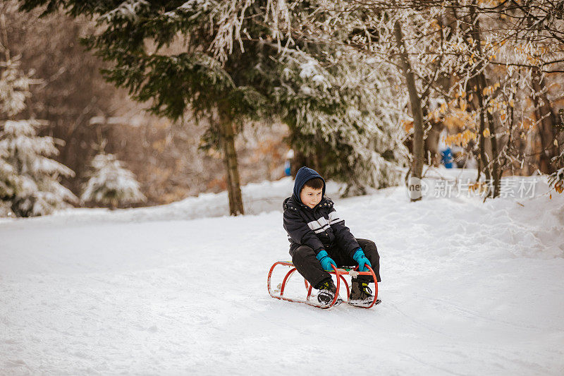 小男孩玩雪橇