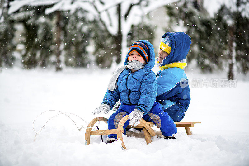 两个微笑的小男孩在雪中滑雪