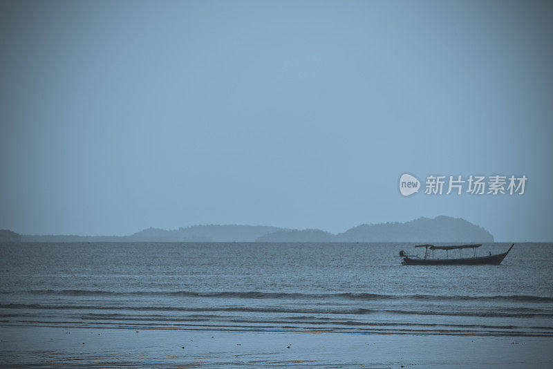 一艘长尾船停泊在泰国Pakarang海滩外。