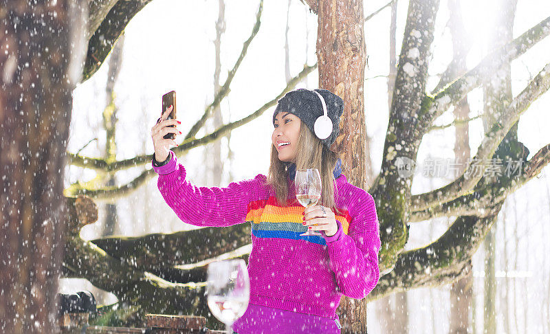 一名女子在雪地里用手机相机自拍