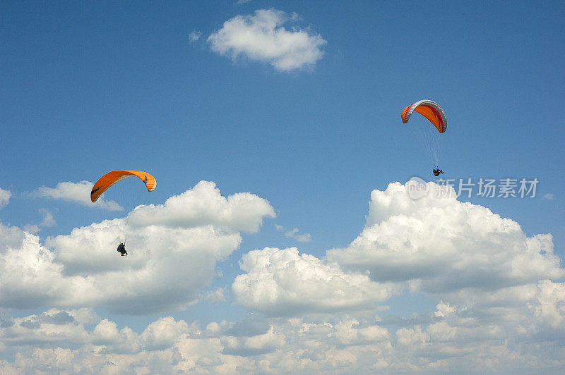 滑翔伞在蓝天中飞翔。两架滑翔伞在白云的背景下在蓝天上飞行。