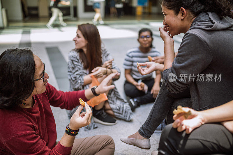 学生们在午休时间在外面吃零食