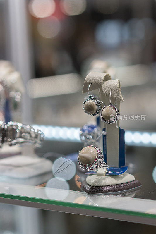 镶有宝石的耳环和戒指。店里有一副耳环和一枚宝石戒指。垂直的照片。
