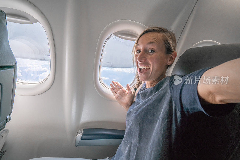 一名年轻女子在飞机上用手机自拍